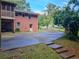 View of a two-story brick house with a screened-in porch, garden, and a paved driveway at 664 Mcburnette Ne Rd, Marietta, GA 30068