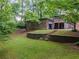 Landscaped backyard featuring a detached garage and a retaining wall at 664 Mcburnette Ne Rd, Marietta, GA 30068