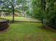 Backyard lawn partially surrounded by a chain link fence and mature trees at 664 Mcburnette Ne Rd, Marietta, GA 30068
