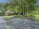 Landscaped front yard features a well-maintained lawn and greenery, with a brick house, and mature trees at 664 Mcburnette Ne Rd, Marietta, GA 30068