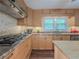 Kitchen featuring wood cabinets, stainless steel appliances, breakfast bar, and wood-look flooring at 664 Mcburnette Ne Rd, Marietta, GA 30068
