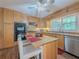 Well-lit kitchen with natural wood cabinets, breakfast bar, stainless steel appliances, and a window overlooking the backyard at 664 Mcburnette Ne Rd, Marietta, GA 30068