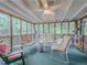 Screened-in porch featuring comfortable seating, a ceiling fan, and peaceful views of surrounding greenery and natural light at 664 Mcburnette Ne Rd, Marietta, GA 30068