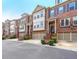 Three-story brick townhomes featuring attached garages and manicured landscaping at 991 Sibley Ne Ln, Atlanta, GA 30324