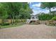 An outdoor patio with a guest house, outdoor kitchen, stone patio and tiered garden bed at 115 Ocee View Ct, Alpharetta, GA 30022