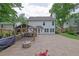 The backyard has an outdoor kitchen, a built in fire pit, a brick patio, a white exterior home and garden at 115 Ocee View Ct, Alpharetta, GA 30022