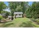 A charming backyard featuring a shed with a deck and a greenhouse, surrounded by manicured landscaping at 115 Ocee View Ct, Alpharetta, GA 30022