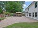 Spacious backyard features a beautiful brick patio with an outdoor kitchen, lush landscaping and a white exterior home at 115 Ocee View Ct, Alpharetta, GA 30022
