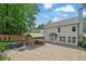 A beautiful backyard that includes an outdoor kitchen, a stone fire pit, a brick patio and a lovely white home at 115 Ocee View Ct, Alpharetta, GA 30022