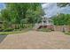 An expansive backyard patio leading to a charming playhouse with a deck and lush landscaping at 115 Ocee View Ct, Alpharetta, GA 30022