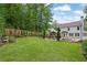 A beautifully landscaped backyard with an outdoor kitchen, a stone patio, a lush green lawn, and privacy fence at 115 Ocee View Ct, Alpharetta, GA 30022