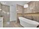 Modern bathroom with a luxurious tub, a separate walk-in shower, and elegant tile work at 115 Ocee View Ct, Alpharetta, GA 30022
