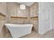 Freestanding modern white tub, surrounded by textured tile walls, with inset woven details at 115 Ocee View Ct, Alpharetta, GA 30022