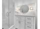 Elegant bathroom featuring a modern vanity, round mirror, decorative lighting, and walk-in shower at 115 Ocee View Ct, Alpharetta, GA 30022