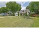A well-manicured front yard features lush green grass, mature trees, and charming landscaping at 115 Ocee View Ct, Alpharetta, GA 30022