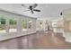 Bright living room leading to a modern kitchen, featuring hardwood floors and backyard access at 115 Ocee View Ct, Alpharetta, GA 30022