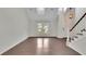 Bright living room featuring hardwood floors, a staircase, and a large window providing ample natural light at 115 Ocee View Ct, Alpharetta, GA 30022
