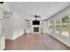 Spacious living room featuring a stone fireplace, built-in shelving, and large windows overlooking the backyard at 115 Ocee View Ct, Alpharetta, GA 30022