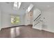 Inviting living room with hardwood floors, a staircase, vaulted ceilings, and bright, natural light at 115 Ocee View Ct, Alpharetta, GA 30022