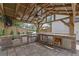 A covered outdoor kitchen boasts a grill, mini-fridge, drawers, stone countertops, and a wood-burning fireplace at 115 Ocee View Ct, Alpharetta, GA 30022