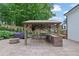 This outdoor kitchen is equipped with a built-in grill, sink, refrigerator, bar and a stone fire pit nearby at 115 Ocee View Ct, Alpharetta, GA 30022