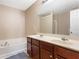 Bathroom with dual sink vanity, bathtub, and neutral walls at 3313 Thornbridge Dr, Powder Springs, GA 30127