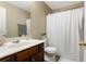 Bathroom featuring a single sink vanity, toilet, and shower with white curtain at 3313 Thornbridge Dr, Powder Springs, GA 30127