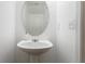 Half bathroom with pedestal sink, oval mirror, and white paint at 3313 Thornbridge Dr, Powder Springs, GA 30127