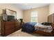 Bedroom features bed, a dresser with a modern flatscreen television, and a window at 3313 Thornbridge Dr, Powder Springs, GA 30127