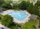 Aerial view of community pool surrounded by lush trees and lounge chairs for relaxing with Gathering and friends at 3313 Thornbridge Dr, Powder Springs, GA 30127