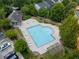 Aerial view of community pool surrounded by lush trees and lounge chairs for relaxing with Gathering and friends at 3313 Thornbridge Dr, Powder Springs, GA 30127