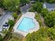 Aerial view of community pool surrounded by lush trees and lounge chairs for relaxing with Gathering and friends at 3313 Thornbridge Dr, Powder Springs, GA 30127