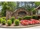 Stone entrance to Carrington community surrounded by manicured landscaping and vibrant flowers at 3313 Thornbridge Dr, Powder Springs, GA 30127