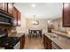 Open kitchen view showcases dark wood cabinets, eat-in dining area, and stainless steel sink at 3313 Thornbridge Dr, Powder Springs, GA 30127