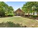 Outdoor pavilion with stone fireplace surrounded by lush greenery and shade trees at 3313 Thornbridge Dr, Powder Springs, GA 30127