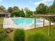 Community pool surrounded by lounge chairs and lush greenery on a sunny day at 3313 Thornbridge Dr, Powder Springs, GA 30127