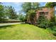 A brick condo building features a green lawn and mature trees providing shade and a connection to nature at 351 Washington Ne Ave # 205, Marietta, GA 30060