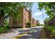 A brick condo building with balconies boasts mature trees and landscaping, offering a charming and inviting appeal at 351 Washington Ne Ave # 205, Marietta, GA 30060