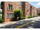A brick condo building with private balconies has well-maintained landscaping, a street, and mature shade trees at 351 Washington Ne Ave # 205, Marietta, GA 30060
