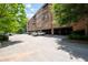 A brick condo building has multiple balconies, a parking lot, and ample parking space beneath the building at 351 Washington Ne Ave # 205, Marietta, GA 30060