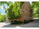 A brick condo building has multiple balconies, covered parking, and is surrounded by green trees and landscaping at 351 Washington Ne Ave # 205, Marietta, GA 30060