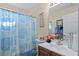 Cozy bathroom with floral shower curtain, vanity with pink flowers, and a large mirror at 3700 Mays Xing, Atlanta, GA 30331
