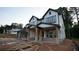 View of exterior featuring white siding, dark trim, and a stone-accented porch of new construction home at 4835 Beechnut Circle, Cumming, GA 30028