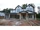 New two-story construction with white siding and dark trim details and a spacious three-car garage at 4835 Beechnut Circle, Cumming, GA 30028