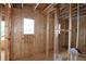 The electrical wiring and bare framing construction of a future room with a window is visible at 4835 Beechnut Circle, Cumming, GA 30028