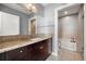 Bathroom with granite countertops, dark wood cabinets, soaking tub, and tiled floors at 905 Juniper Ne St # 708, Atlanta, GA 30309