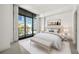 Bright bedroom featuring a large window, neutral color palette, plush bedding, and a city view at 905 Juniper Ne St # 708, Atlanta, GA 30309