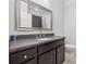 Well-lit bathroom featuring dark cabinets, a large mirror, and granite counters at 1106 Briar Cove Cir, Atlanta, GA 30329