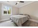 Carpeted bedroom featuring a ceiling fan and large window with a view of the yard at 1106 Briar Cove Cir, Atlanta, GA 30329