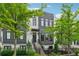 Contemporary two-story townhome featuring a dark-trimmed facade, landscaped yard, and steps to the front door at 1106 Briar Cove Cir, Atlanta, GA 30329